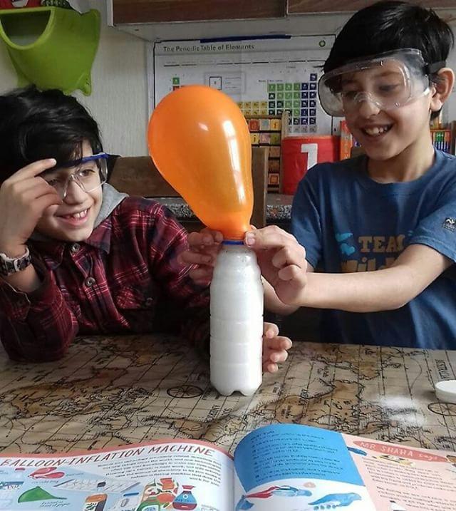 Two of their children doing a science experiment at home