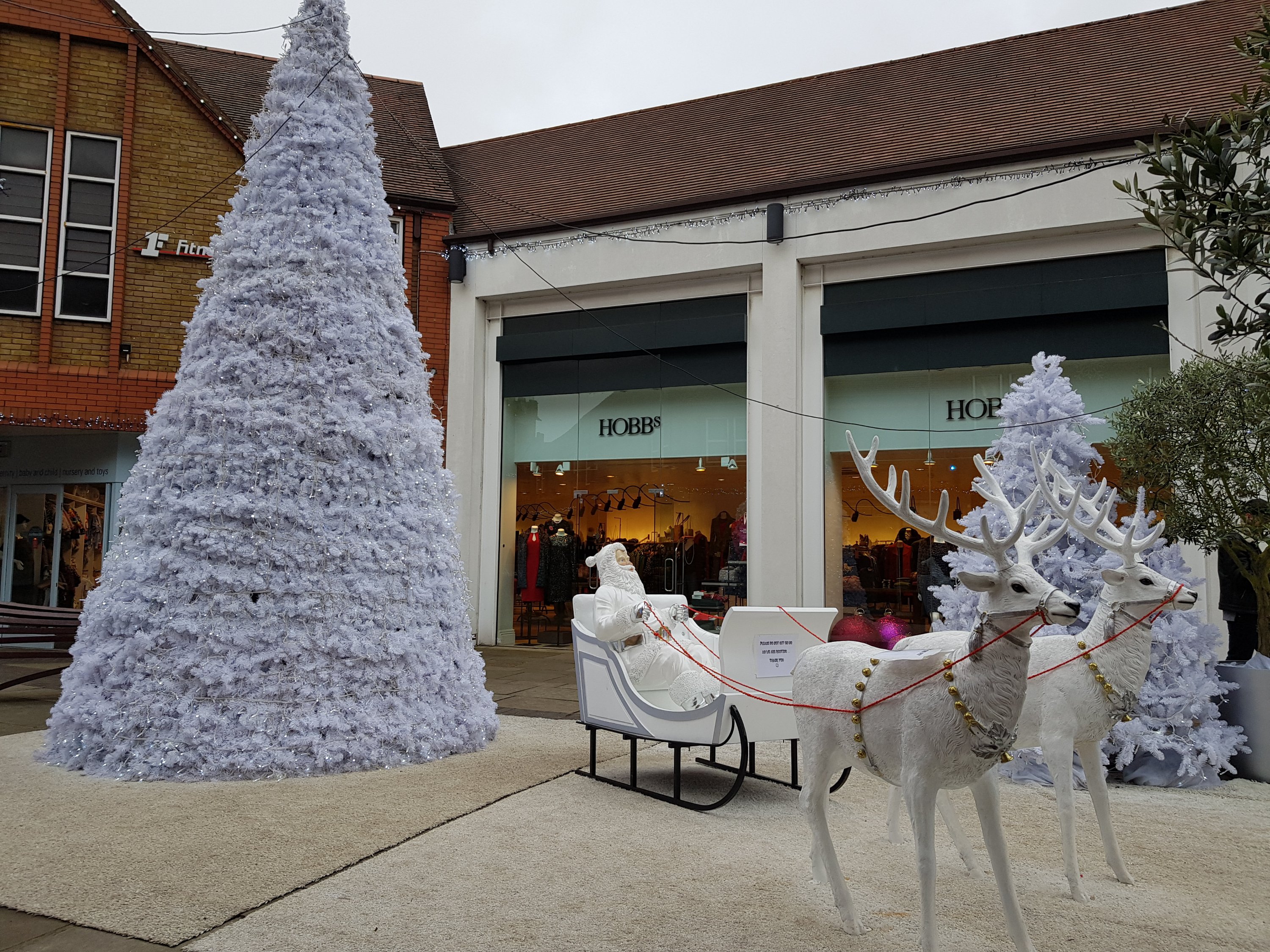 Santa in a sleigh with reindeer and christmas tree in Christopher Place festive display St Albans 