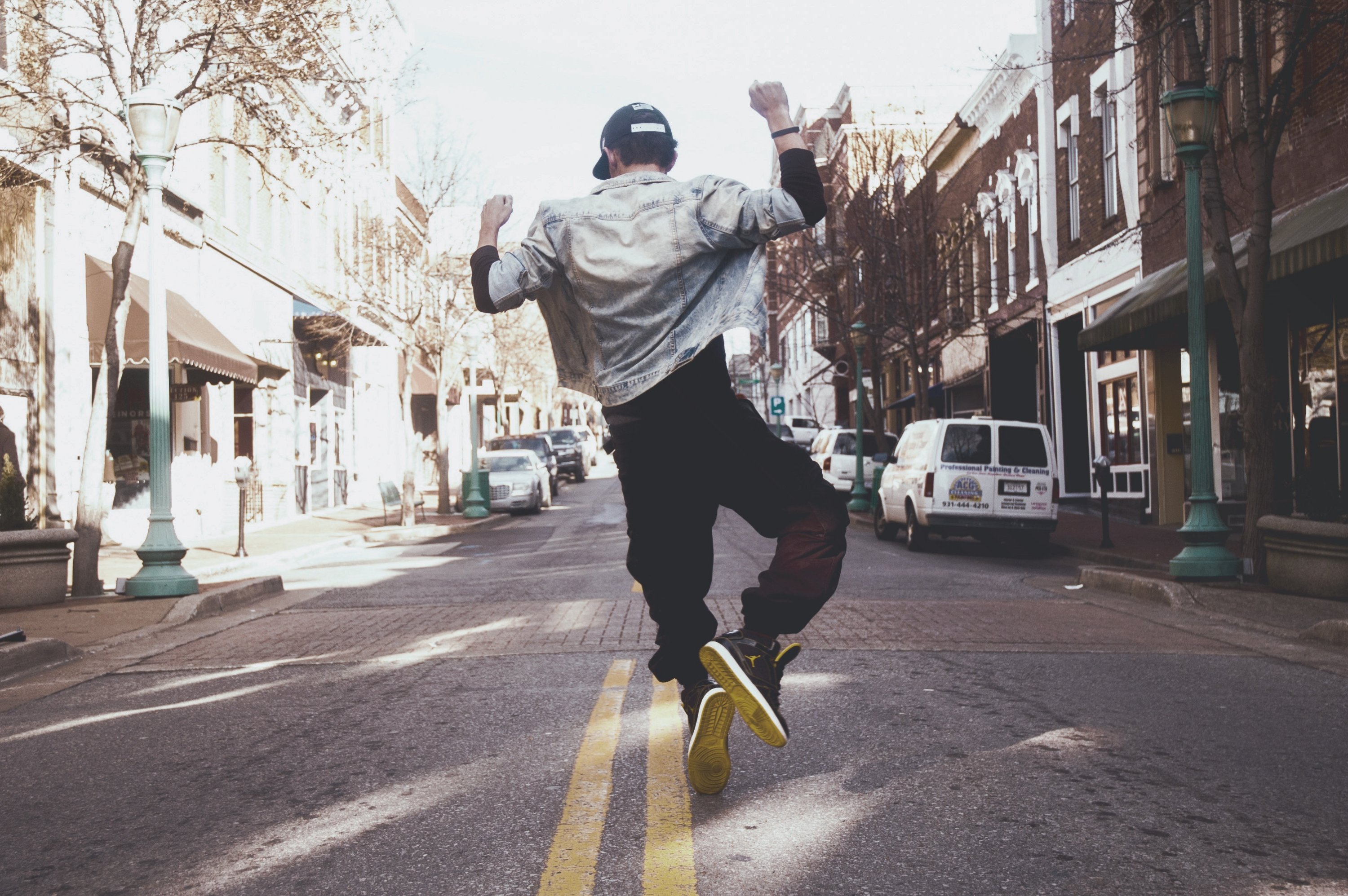 Man in street jumping with joy/ dancing