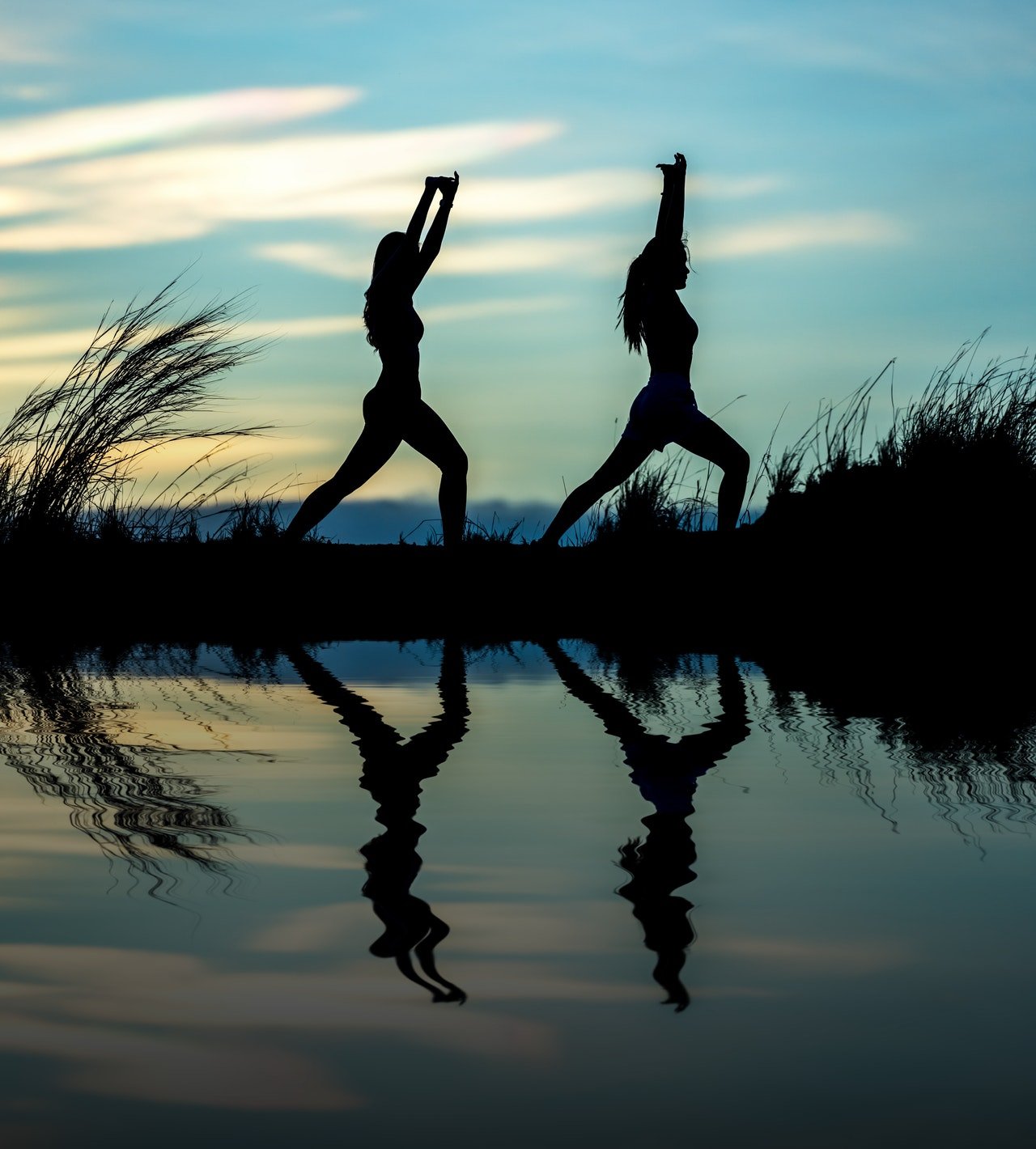 Silhouette of two women doing yoga outdoors
