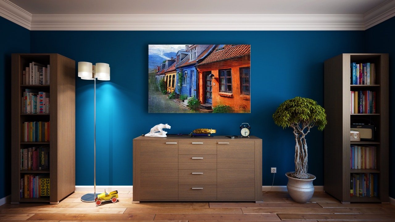 Dark blue painted wall. Picture hanging on wall. Home decor. Interior design
