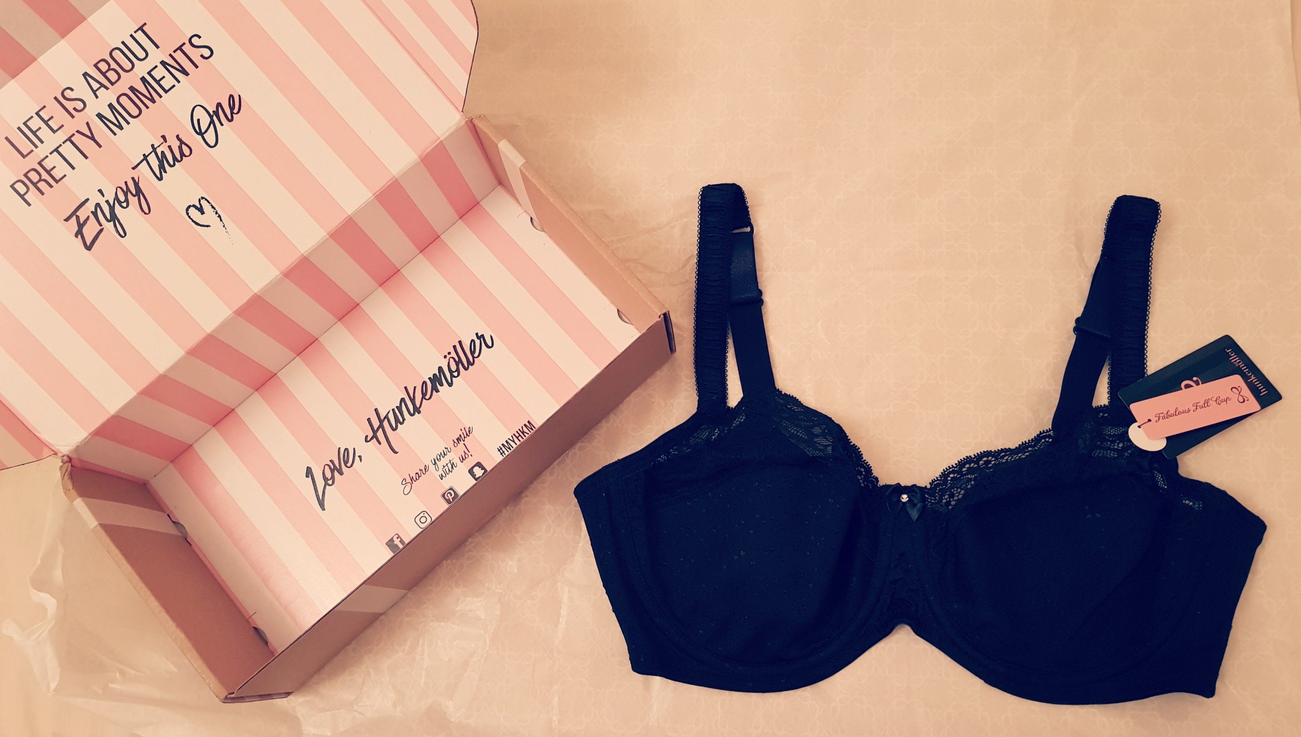 Hunkemoller underwired non padded black bra flatlay. Pretty box next to it says life is about pretty moments, enjoy this one. Love, hunkemoller 