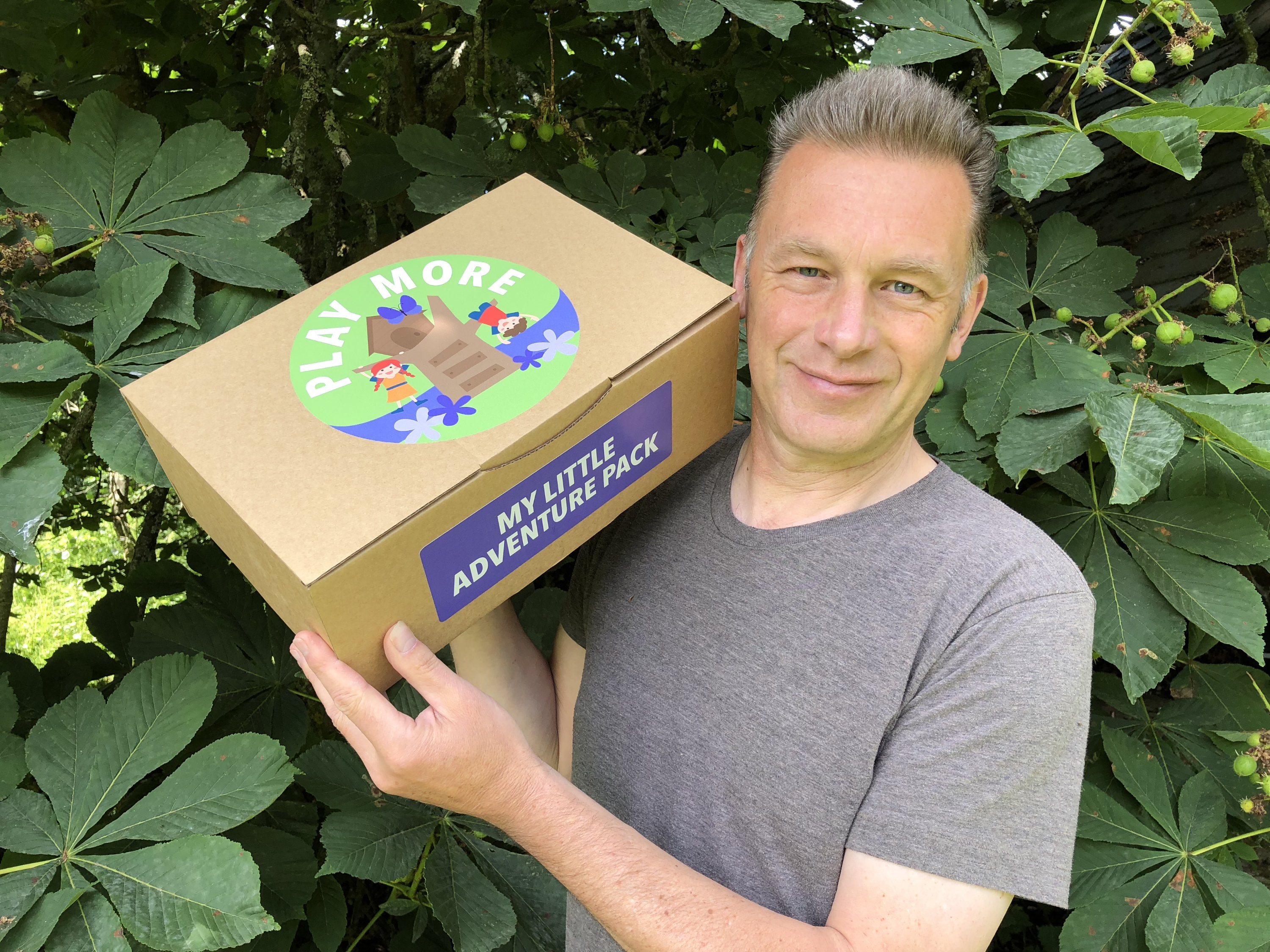 Chris Packham holding a Play More box