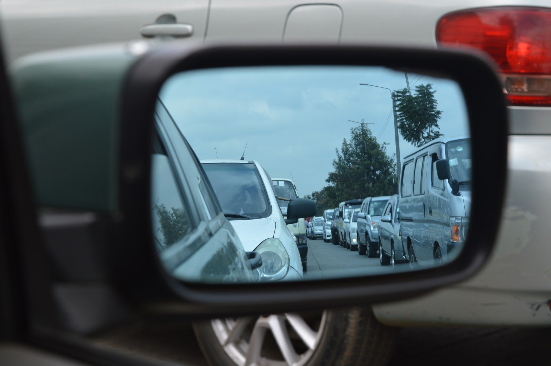 Queue of traffic in rear view car mirror