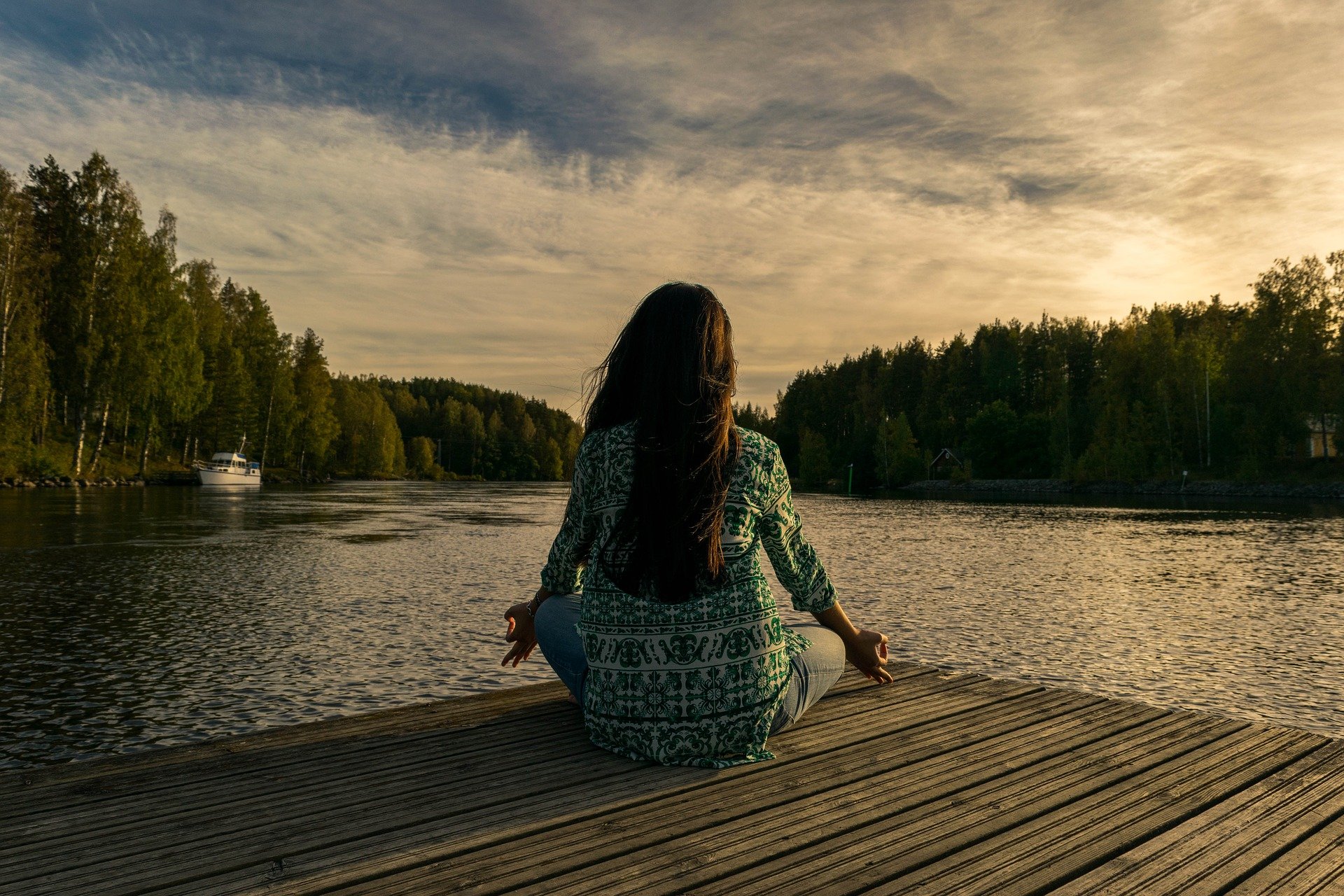 Woman meditating next to lake
