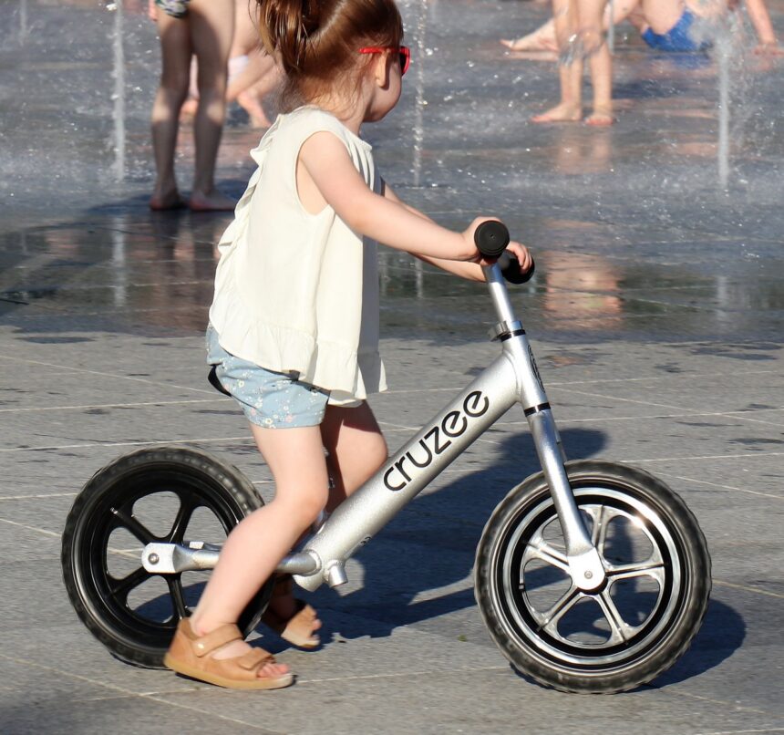 Balance bike vs stabilisers. Girl on balance bike.