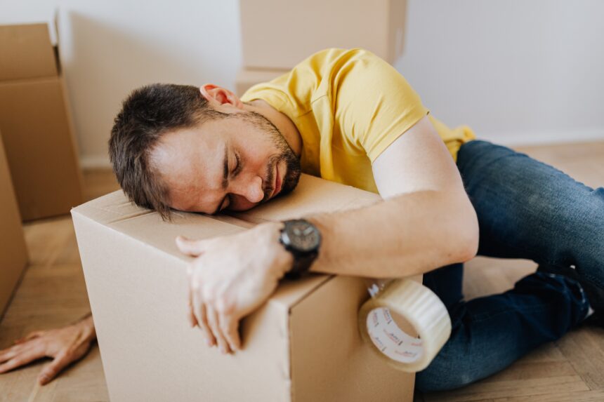 Man lying on moving box - Mortgages: How Much Can You Cut The Cost Of Buying A House
