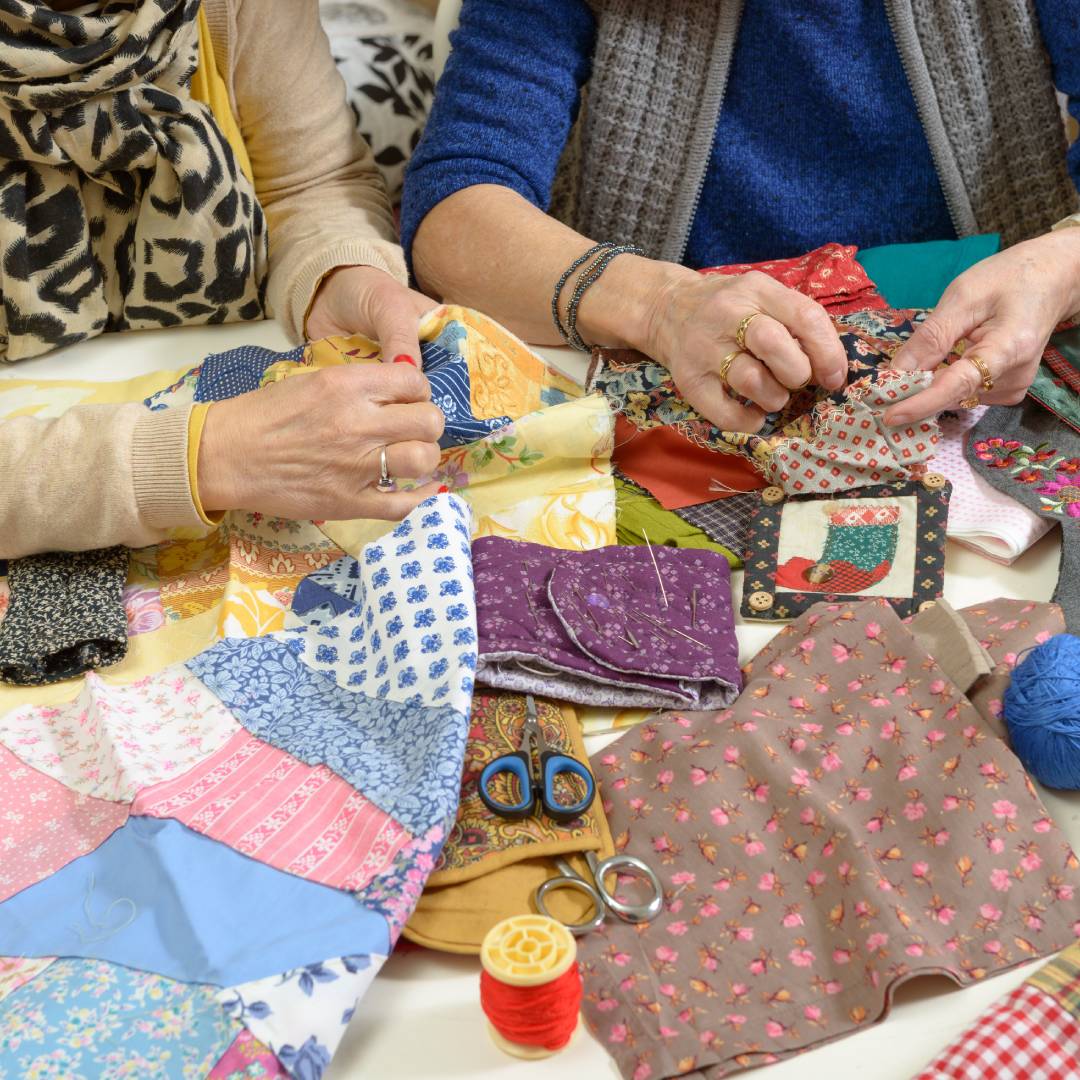 A pair of friends sitting together for a little social time and bonding over their shared love of quilting.