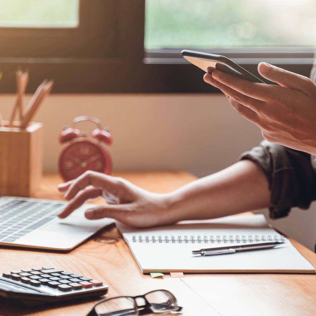 Young businesswoman works on a laptop at her home office desk, focused and productive in a cozy workspace.